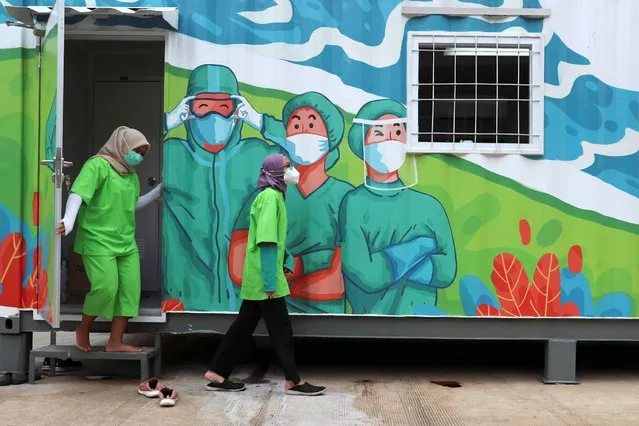 Health workers walk out of a mobile laboratory before analyzing samples collected during mass coronavirus tests in Jakarta, Indonesia, Thursday, June 18, 2020. (Photo by Achmad Ibrahim/AP Photo)