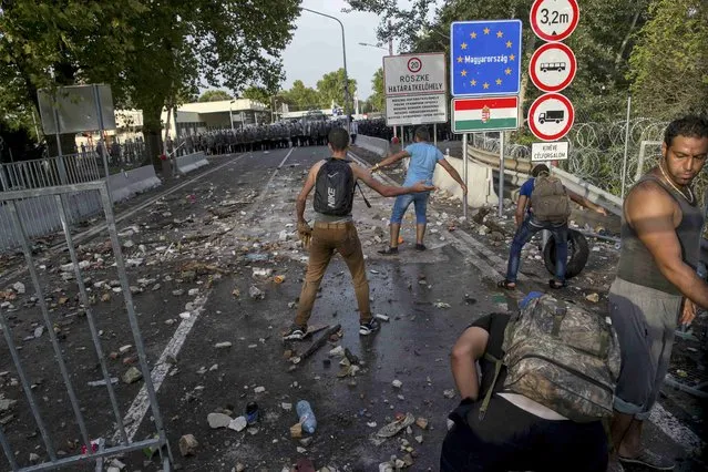 Migrants taunt Hungarian riot police during clashes at the border crossing with Serbia in Roszke, Hungary September 16, 2015. (Photo by Marko Djurica/Reuters)