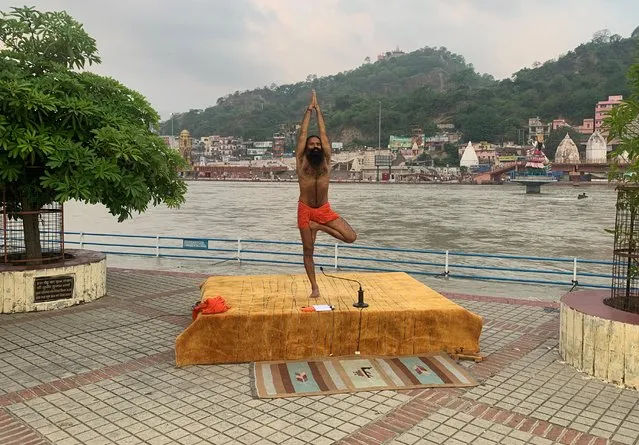 India's yoga guru Baba Ramdev performs yoga on the banks of the river Ganges ahead of International Yoga day, in the northern town of Haridwar, India, June 19, 2020. (Photo by Sunil Kataria/Reuters)