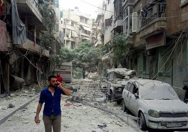 A handout picture made available by Syrian arab news agency SANA shows Syrian citizens inspect the damages caused by several rocket that hit some residential neighborhoods in the northern city of Aleppo, Syria, on 25 August 2016. According to media reports, the rounds killed at least six civilians and wounded 34 others, some critically. (Photo by EPA/SANA)