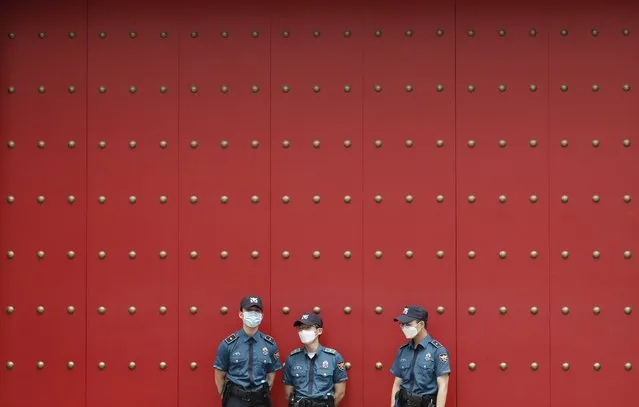 South Korean police officers wearing face masks to help protect against the spread of the new coronavirus, stand guard in downtown Seoul, South Korea, Tuesday, July 7, 2020. (Photo by Lee Jin-man/AP Photo)