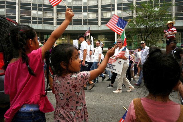 From the sidewalk, the Ramirez family show support waving American flags as the demonstrators walk through the streets of downtown during the “Mega Marcha”, calling for immigration reform, in Dallas, Texas on March 30, 2025. (Photo by Jeremy Lock/Reuters)