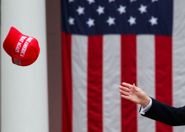 U.S. President Donald Trump tries to reach a MAGA hat, on the day of his remarks on tariffs in the Rose Garden at the White House in Washington on April 2, 2025. (Photo by Carlos Barria/Reuters)