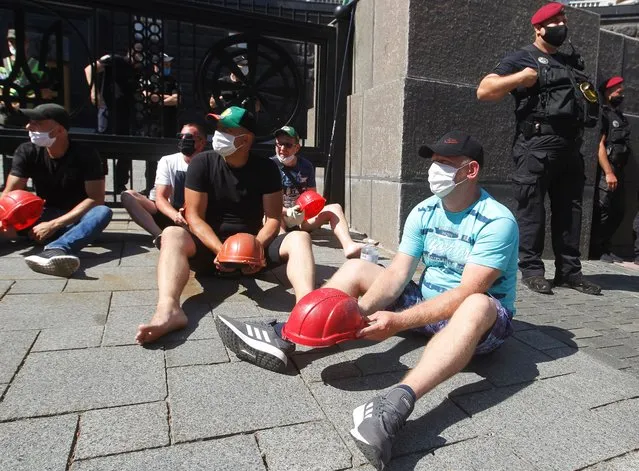 Ukrainian miners hit their helmets on the ground on the seventh day of their All-Ukrainian indefinite protest near the Cabinet of Ministers in Kyiv, Ukraine, on 6 July, 2020. The miners demand salary debt repayment, resumption of coal mines and prohibition of import of electricity and coal of gas grades from the Russia and Belarus, said the protestors. (Photo by NurPhoto via Getty Images)