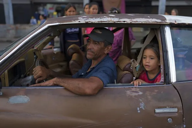 A family moves in a dilapidated car in Maracaibo, Venezuela, Thursday, October 13, 2022. (Photo by Ariana Cubillos/AP Photo)
