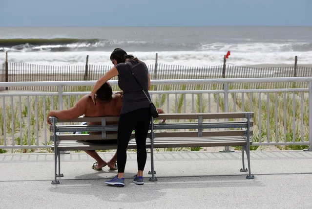 A woman massages a man's shoulders at Rockaway Beach in Queens, New York on Labor Day where people enjoyed brief rays of sun despite closures due to post-tropical cyclone Hermine which tracked off the east coast of the U.S. September 5, 2016. (Photo by Mark Kauzlarich/Reuters)