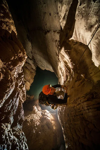 Tristan Godet jugs up a rope after having discovered a new cave passage. (Photo by Francois-Xavier De Ruydts/Caters News)
