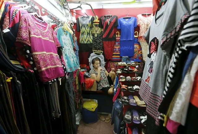A woman waits for customers in her clothes stall at Glodok neighborhood in Jakarta, Indonesia, May 4, 2015. Indonesia's economy is expected to have slowed further in the first quarter as falling exports, weak domestic consumption and policy inertia raise doubts about President Joko Widodo's promise to spur a revival in growth and investor confidence.   REUTERS/Beawiharta 