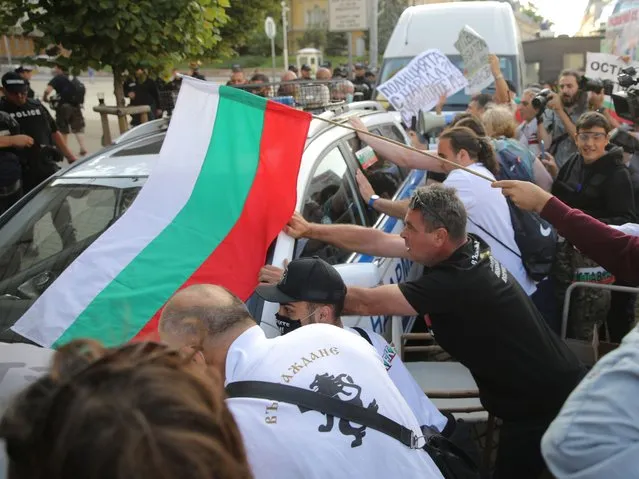 People take part in an anti-government demonstration in Sofia, Bulgaria, September 2, 2020. In the biggest protest so far in nearly two months of anti-government rallies, hundreds of police officers in riot gear on Wednesday cordoned off the parliament building trying to protect it from protesters who were throwing stones and plastic bottles, eggs and garbage. Police answered by firing pepper spray at them. (Photo by Stoyan Nenov/Reuters)