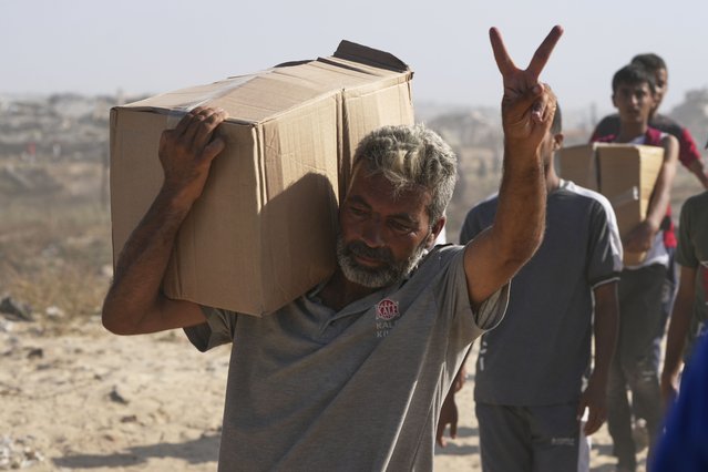 A Palestinian man faces V-sign as he carries a box containing food and humanitarian aid packages delivered by the Gaza Humanitarian Foundation, a U.S.-backed organization approved by Israel, in Rafah, southern Gaza Strip, on Tuesday, May 27, 2025. (Photo by Abdel Kareem Hana/AP Photo)