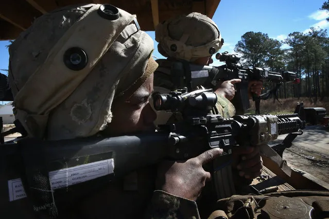 Pvt. Tia Meeks (L) from Little Rock, Arkansas and Pvt. Lindsay Edsall of reading, Pennsylvania keep watch in a guard tower during war games during Marine Combat Training (MCT) on February 20, 2013 at Camp Lejeune, North Carolina.  Since 1988 all non-infantry enlisted male Marines have been required to complete 29 days of basic combat skills training at MCT after graduating from boot camp. MCT has been required for all enlisted female Marines since 1997. About six percent of enlisted Marines are female.  (Photo by Scott Olson)