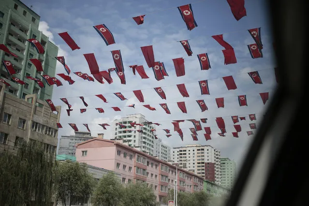 North Korean flags are flown between apartment blocks in downtown Pyongyang, North Korea, Wednesday, August 24, 2016. (Photo by Dita Alangkara/AP Photo)