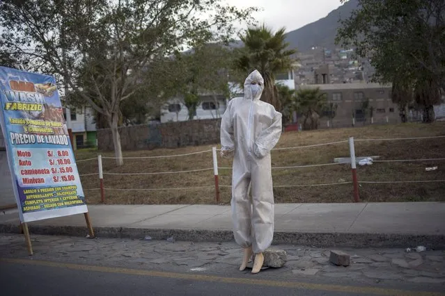 A mannequin dressed in protective gear due to the COVID-19 pandemic, is deployed in front of a car wash to attract customers, in Lima, Peru, Monday, August 10, 2020. (Photo by Rodrigo Abd/AP Photo)