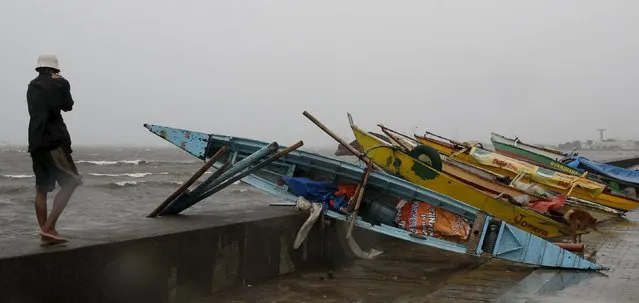 A fisherman looks at rough seas near his boat that was put up in baywalk with other boats due to Typhoon Koppu in Manila, October 18, 2015. Powerful typhoon Koppu ploughed into the northeastern Philippines before dawn on Sunday destroying homes and displacing 10,000 people and whipping up coastal surges four meters (12 feet) high, disaster agency officials said. (Photo by Erik De Castro/Reuters)