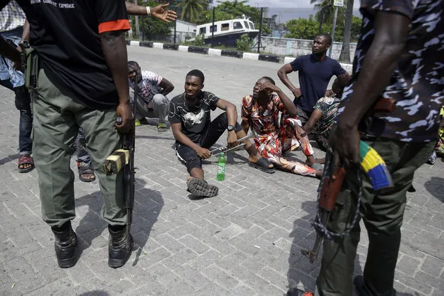 Police officers stop and search a bus carrying passengers around Lekki toll gate in Lagos Friday, October 23, 2020. Resentment lingered with the smell of charred tires Friday as Nigeria's streets were relatively calm after days of protests over police abuses, while authorities gave little acknowledgement to reports of the military killing at least 12 peaceful demonstrators earlier this week. (Photo by Sunday Alamba/AP Photo)