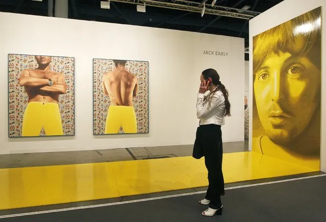 An attendee looks over art at Art Basel in Miami Beach December 4, 2014. An estimated 70,000 art enthusiasts have converged on the city during its annual contemporary “Art Week”, centered around an event called the Art Basel Miami Beach fair. A handful of gallery owners have begun shying away, citing rising rents, few art buyers and condominium development. (Photo by Andrew Innerarity/Reuters)