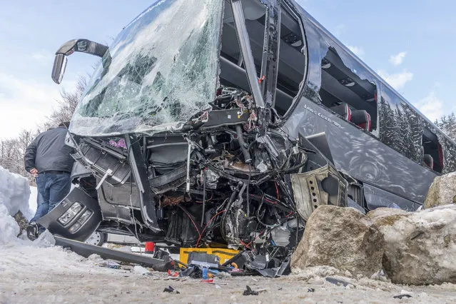 A rescuer works at the wreckage of a bus that crashed in Gosen near Salzburg, Austria, Wednesday, March 28, 2018. Austrian police say more than 20 people were injured when a bus carrying South Korean tourists crashed in Gosen near Salzburg. Police in upper Austria say the Croatian driver and a South Korean tourist were seriously injured, while more than 20 others suffered minor injuries in Wednesday's crash. (Photo by Werner Kerschbaumayr /FotoKerschi.at/Kerschbaummayr via AP Photo)