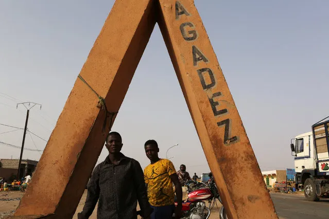 Men walk by a sign at the entrance of Agadez, Niger, May 10, 2016. (Photo by Joe Penney/Reuters)