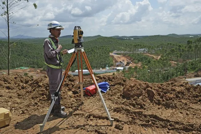 Worker uses his equipment at the construction site of the new capital city in Penajam Paser Utara, East Kalimantan, Indonesia, Wednesday, March 8, 2023. Indonesia began construction of the new capital in mid 2022, after President Joko Widodo announced that Jakarta – the congested, polluted current capital that is prone to earthquakes and rapidly sinking into the Java Sea — would be retired from capital status. (Photo by Achmad Ibrahim/AP Photo)
