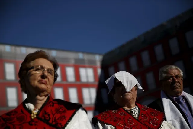 A woman in traditional costume shades her face from the sun during an open-air mass to celebrate Madrid's patron saint La Almudena Virgin in Madrid, Spain, November 9, 2015. (Photo by Susana Vera/Reuters)