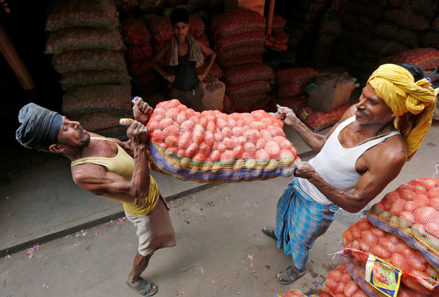 Labourers lift a sack of potatoes to load onto a supply truck at a wholesale market in Kolkata, India, October 14, 2016. (Photo by Rupak De Chowdhuri/Reuters)