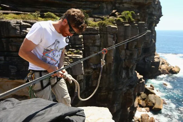 Luke Sarantos checks his harness and makes final preparations to a slackline between two cliffs at Diamond Bay on December 21, 2014 in Sydney, Australia. (Photo by Cameron Spencer/Getty Images)