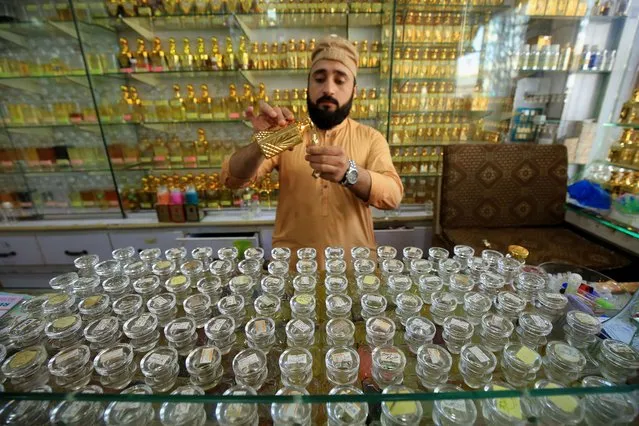 A man sells non-alcoholic perfumes on a shop during the fasting month of Ramadan, in Peshawar, Pakistan, 27 March 2023. (Photo by Arshad Arbab/EPA/EFE)