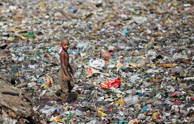 A boy walks on a pile of garbage covering a drain in New Delhi, India, April 23, 2018. (Photo by Adnan Abidi/Reuters)