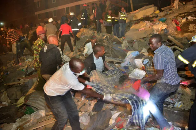 Rescue workers help the injured at the site of a multi-storey building collapse  in the capital Nairobi, Kenya Sunday, January 4, 2015. (Photo by AP Photo)