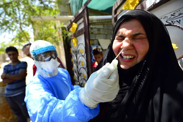 An Iraqi medic takes a nasal swab from a woman in Iraq's central shrine city of Najaf on April 20, 2020, during the nationwide lockdown to stem the spread of the novel coronavirus. (Photo by Haidar Hamdani/AFP Photo)