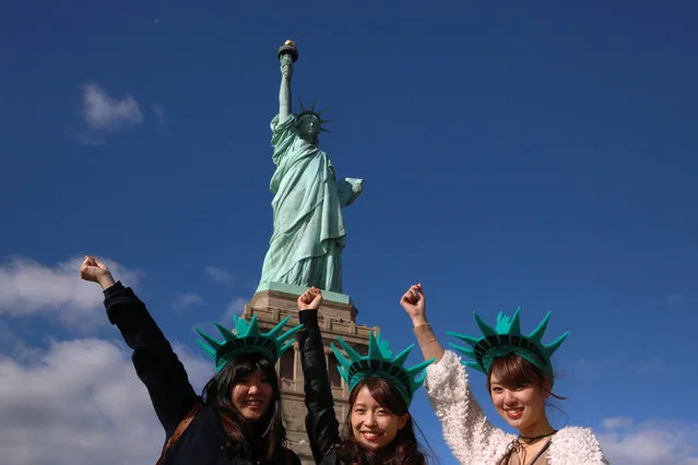 Japanese tourists pose in front of the Statue of Liberty on the 130th anniversary of the dedication in New York Harbor, in New York City, U.S., October 28, 2016. (Photo by Brendan McDermid/Reuters)