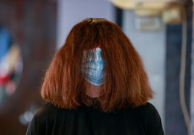 A costumer in a protective mask at the hair saloon 'Le Studio', in Brussels, Belgium, 18 Mai 2020. Belgium eased lockdown measur​es in place to curb the spread of the COVID-19. (Photo by Stéphanie Lecocq/EPA/EFE)