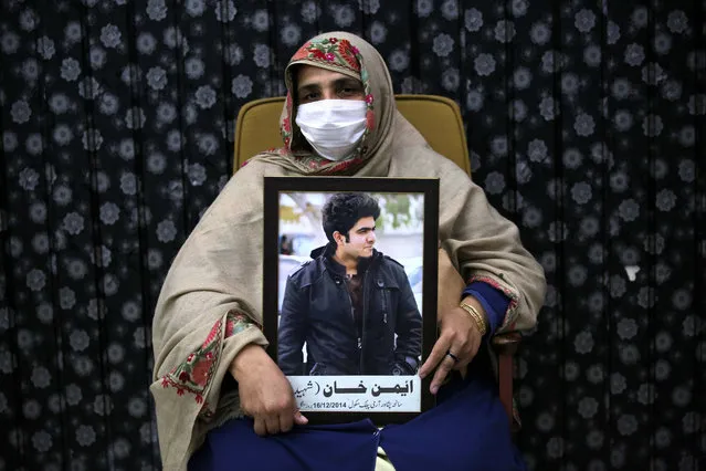 A mother holds the portrait of victim of Army Public School (APS) attack, during a ceremony on the eve of the sixth anniversary of the Peshawar school attack, in Peshawar, Pakistan, 15 December 2020. In December 2014 Taliban militants attacked the army-run Army Public School in the north-western city of Peshawar, where about 150 people, mostly students, were killed. (Photo by Bilawal Arbab/EPA/EFE)