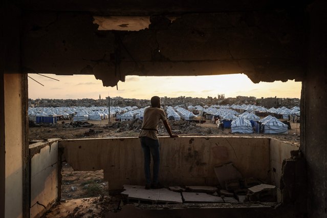 A Palestinian man looks out at a new displacement camp set up by the Egyptian Committee in Nuseirat, Gaza Strip on November 11, 2025. (Photo by Eyad Baba/AFP Photo)