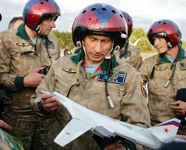 Vladimir Putin looks at a model of the Tupolev TU-160 bomber, or Blackjack, that was presented to him on his arrival in Olenegorsk, Russia, August 16, 2005. Putin flew in the Tupolev TU-160 bomber and took part in the launch of cruise missiles in the Arctic north. (Photo by Reuters/ITAR-TASS/Presidential Press Service)