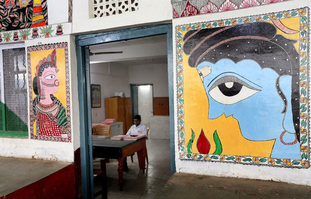 An Indian railway offcial sits in his office painted with Madhubani artworks at the Madhubani railway station in Bihar, India, 07 April 2018. (Photo by Harish Tyagi/EPA/EFE)