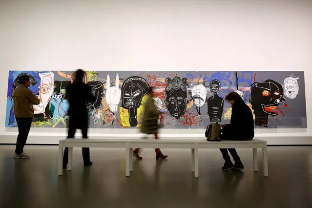 People walk past the painting “African Masks” (1984) by artists Jean-Michel Basquiat (1960-1988) and Andy Warhol (1928-1987) during a press visit of the exhibition “Basquiat x Warhol, Painting Four Hands” at the Fondation Louis Vuitton in Paris, France on April 4, 2023. (Photo by Sarah Meyssonnier/Reuters)