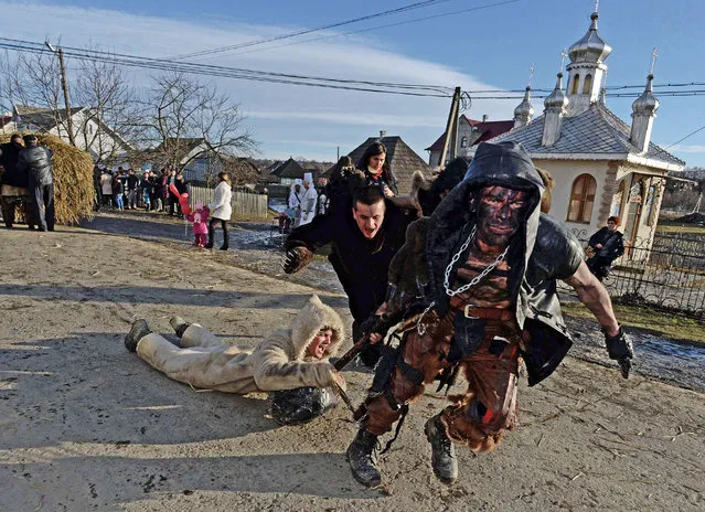 People dressed in traditional costumes celebrate the Malanka festival in the village of Krasnoilsk, Chernivtsi district, on January 14, 2014. (Photo by Vasily Maximov/AFP Photo)