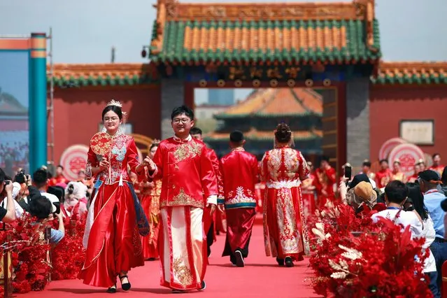 Couples attend a mass wedding ceremony at the Shenyang Imperial Palace in Shenyang, in China's northeastern Liaoning province on May 22, 2023. (Photo by AFP Photo/China Stringer Network)