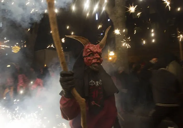 A reveller wearing a demon costume takes part in the traditional festival of “Correfoc” in Palma de Mallorca, on January 17, 2015. (Photo by Jaime Reina/AFP Photo)