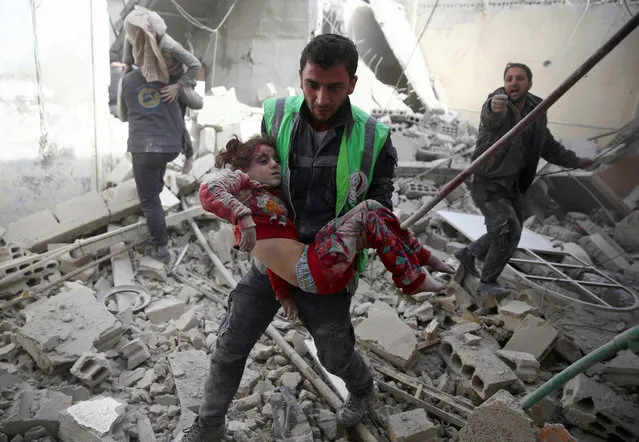 A civil defence member carries an injured girl after an airstrike in the rebel-held Douma neighbourhood of Damascus, Syria November 7, 2016. (Photo by Bassam Khabieh/Reuters)