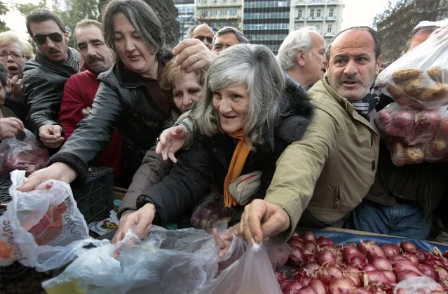 Greeks struggle as they wait to receive free onions and other vegetables offered by farmers in Syntagma Square in this January 25, 2012 file photo. (Photo by Yannis Behrakis/Reuters)