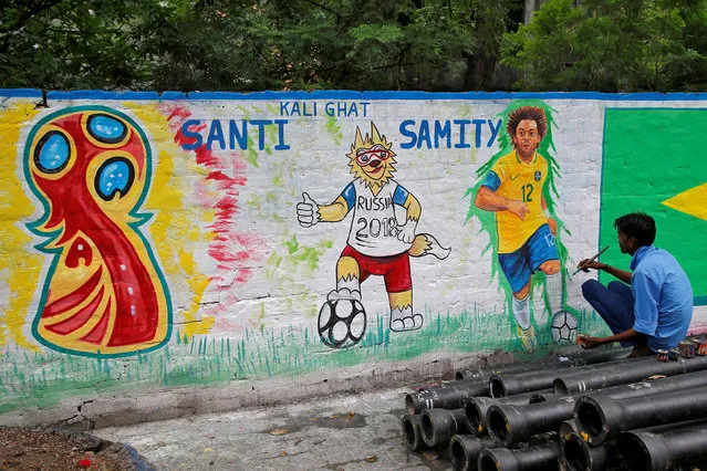 A painter applies finishing touches to an image of Brazil's player Marcelo on a wall along a road ahead of the FIFA World Cup, in Kolkata, June 4, 2018. (Photo by Rupak De Chowdhuri/Reuters)