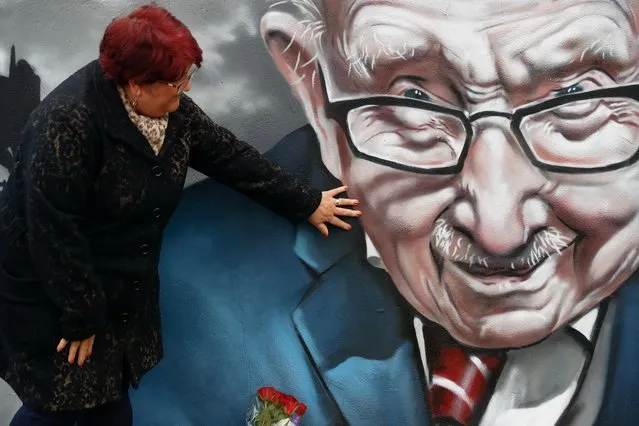 A woman places her hand on a mural of late record-breaking centenarian Captain Tom Moore, who died on Tuesday, in Two Gates, Tamworth, Britain on February 3, 2021. (Photo by Jason Cairnduff/Reuters)