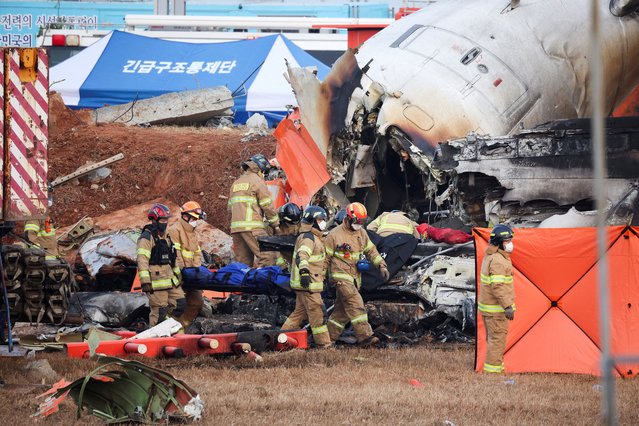 Firefighters carry the body of a passenger from the wreckage of an aircraft that crashed after it went off the runway at Muan International Airport, in Muan, South Korea, on December 29, 2024. (Photo by Kim Hong-Ji/Reuters)