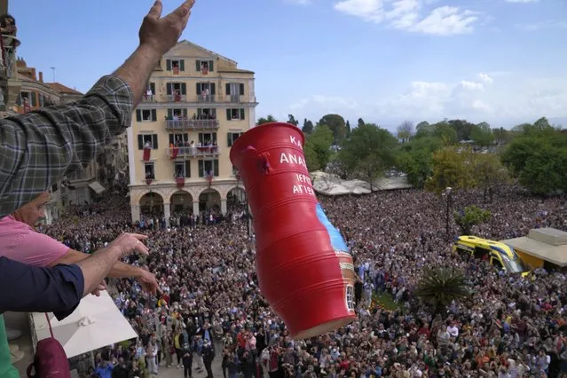 People throw a huge clay jar from a balcony as thousands of visitors watch the custom called “botides” on the Ionian Sea island of Corfu, northwestern Greece, on Saturday, April 23, 2022. For the first time in three years, Greeks were able to celebrate Easter without the restrictions made necessary by the coronavirus pandemic. (Photo by Thanassis Stavrakis/AP Photo)