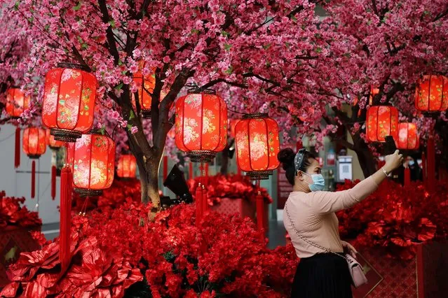 A woman wearing a protective mask takes a selfie in front of Lunar New Year decoration at a shopping mall, during a lockdown due to the coronavirus disease (COVID-19) outbreak, in Kuala Lumpur, Malaysia on January 21, 2021. (Photo by Lim Huey Teng/Reuters)