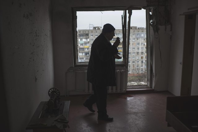 Vladimir Bulatkin uses a mobile phone as he examined his apartment damaged in Saturday's shelling at Vostochniy district of Mariupol, Ukraine, Monday, January 26, 2015. At least 5,100 people have been killed in eastern Ukraine since fighting began in April 2014, but violence this week was the most intense since a cease-fire deal was signed in September. (Photo by Evgeniy Maloletka/AP Photo)