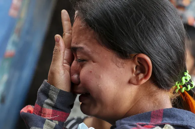 Thae Nu Naing, sister of Saw Pyae Naing weeps by his body at their home in Mandalay, Myanmar, Sunday, March 14, 2021. Saw Pyae Naing, a 21-year old anti-coup protester was shot and killed by Myanmar security forces during a demonstration on Saturday, according to his family. (Photo by AP Photo/Stringer)