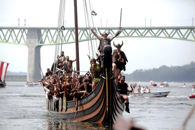 People dressed as Vikings sail on a boat during the annual Viking festival of Catoira in north-western Spain on August 5, 2018. (Photo by Miguel Vidal/Reuters)